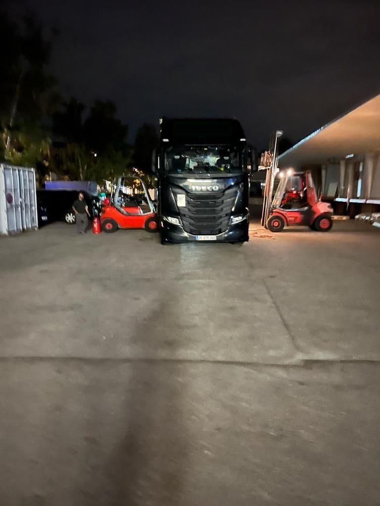 Zwei Gabelstapler, die einen LKW von beide Seiten beladen